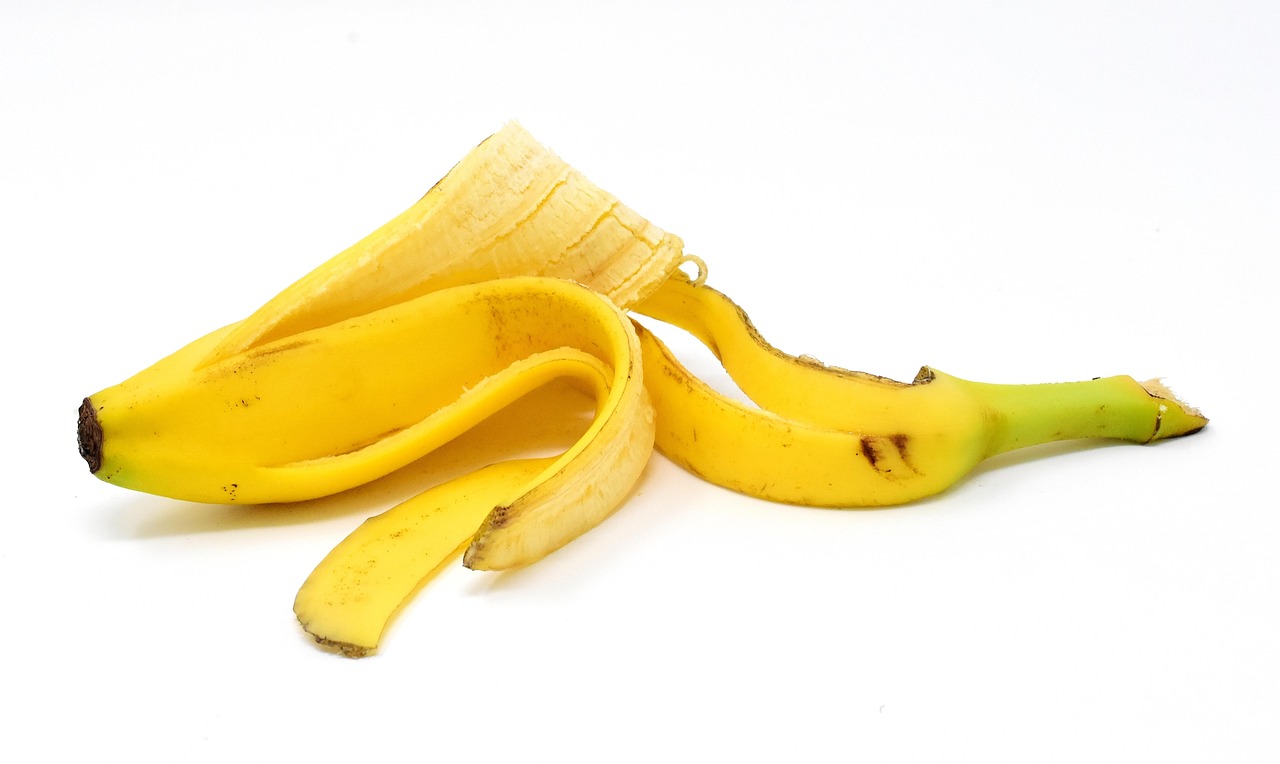 Buccia di banana accanto a una pianta in vaso, simbolo di fertilizzante naturale per piante domestiche.