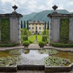 Giardino all'italiana di una villa da sogno, con piante curate e fiori colorati in un ambiente sereno.